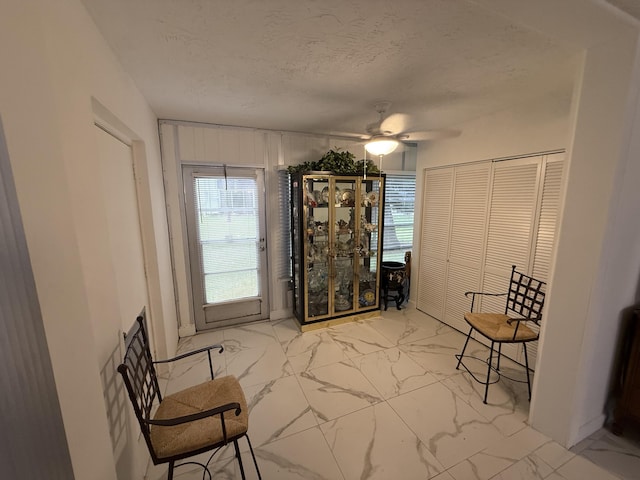 unfurnished room featuring ceiling fan and a textured ceiling