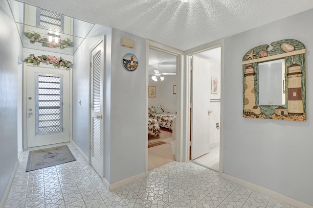 tiled entrance foyer featuring ceiling fan and a textured ceiling