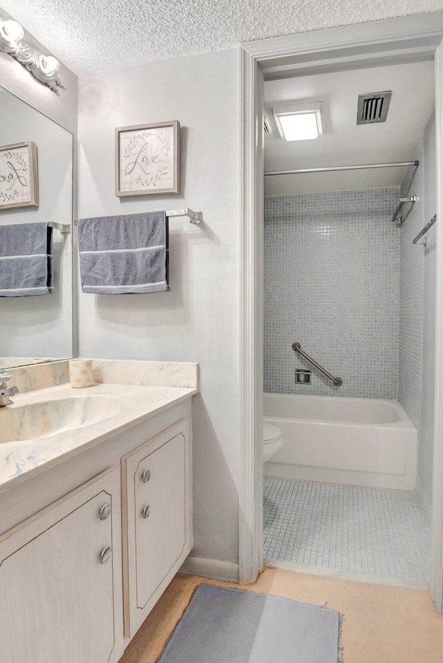 full bathroom with vanity, tiled shower / bath combo, a textured ceiling, tile patterned floors, and toilet