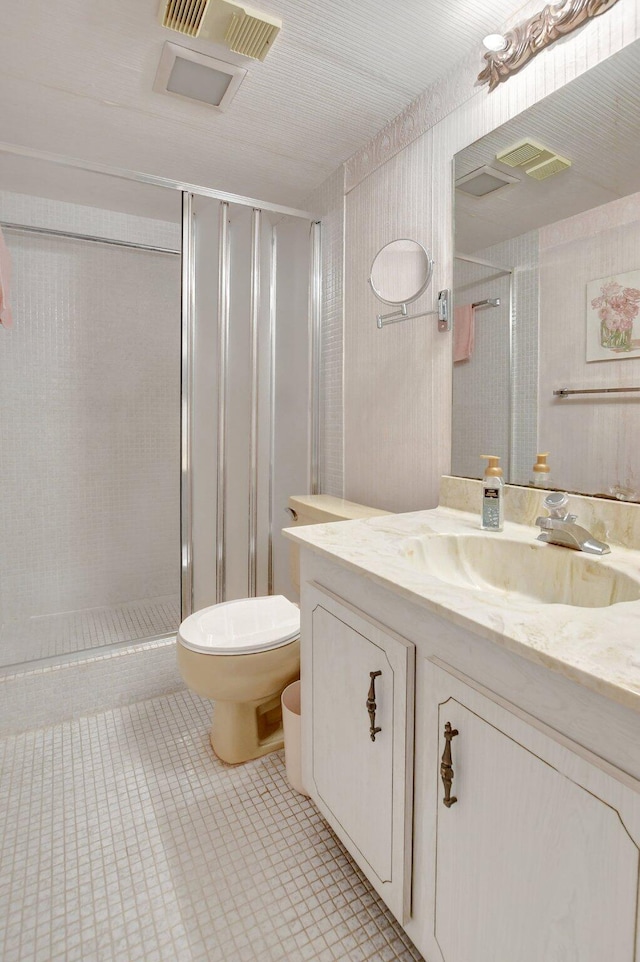 bathroom featuring vanity, toilet, and an enclosed shower