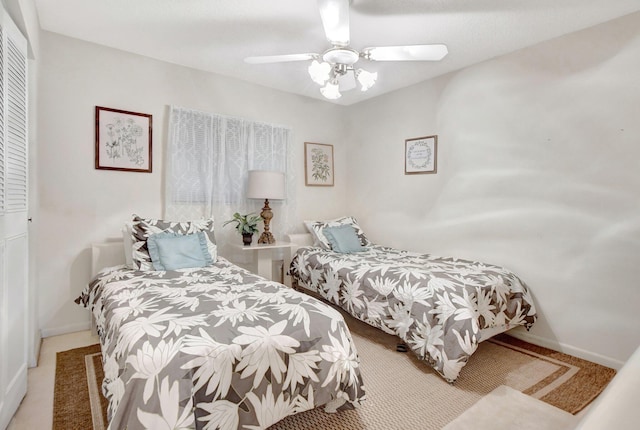 carpeted bedroom featuring ceiling fan and a closet