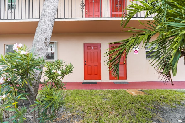 view of exterior entry with a balcony