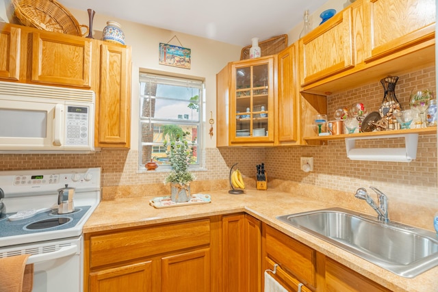 kitchen featuring white appliances, backsplash, and sink