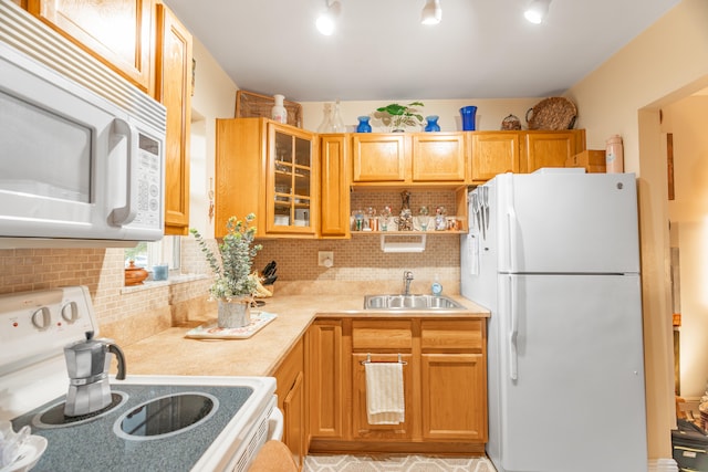 kitchen with white appliances, backsplash, and sink