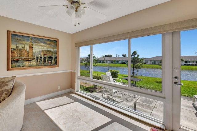 sunroom / solarium with a water view and ceiling fan