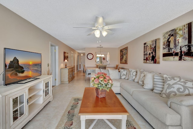 living room with a textured ceiling and ceiling fan with notable chandelier