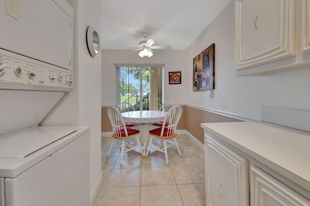 tiled dining area with stacked washer / drying machine and ceiling fan