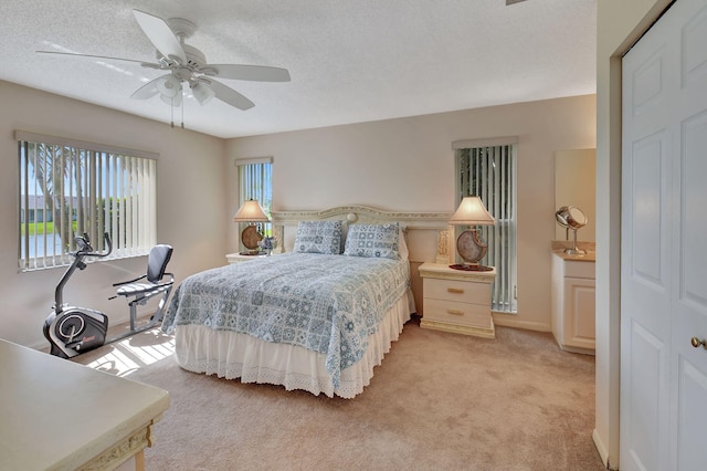 bedroom featuring light carpet, a textured ceiling, a closet, and ceiling fan