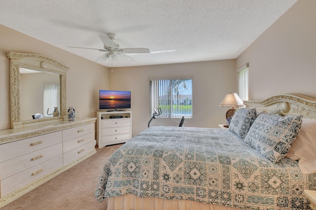 carpeted bedroom featuring a textured ceiling and ceiling fan