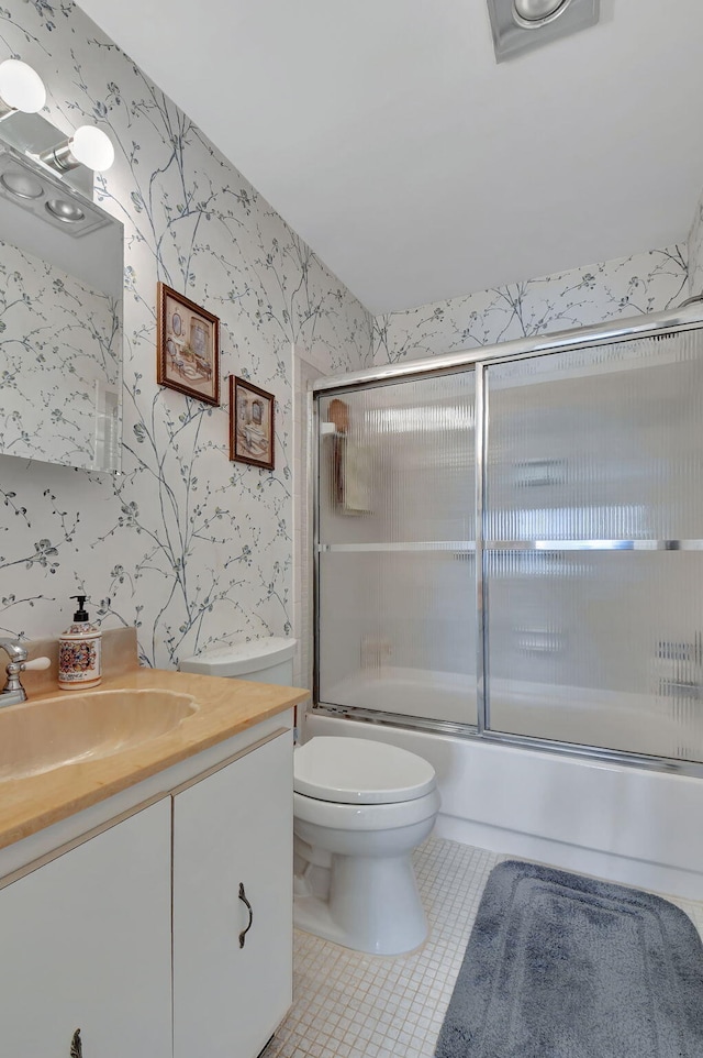 full bathroom with vanity, enclosed tub / shower combo, tile patterned flooring, and toilet