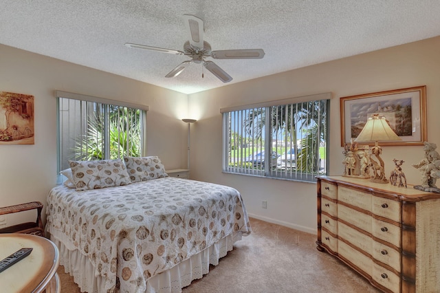 bedroom with light carpet, a textured ceiling, and ceiling fan