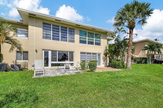 rear view of property with a yard, cooling unit, and a patio