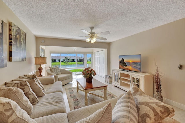 living room featuring ceiling fan and a textured ceiling