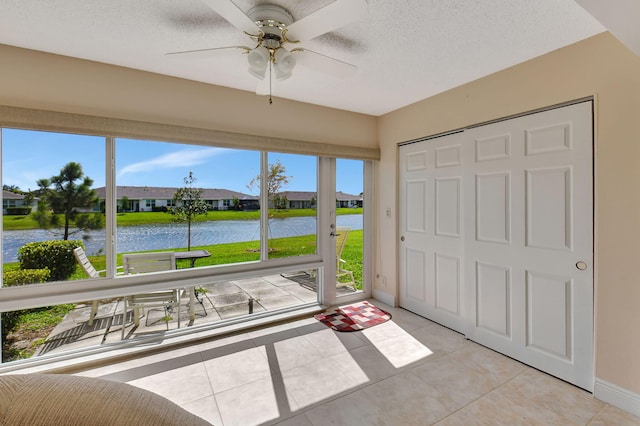 unfurnished sunroom with a water view, ceiling fan, and a wealth of natural light