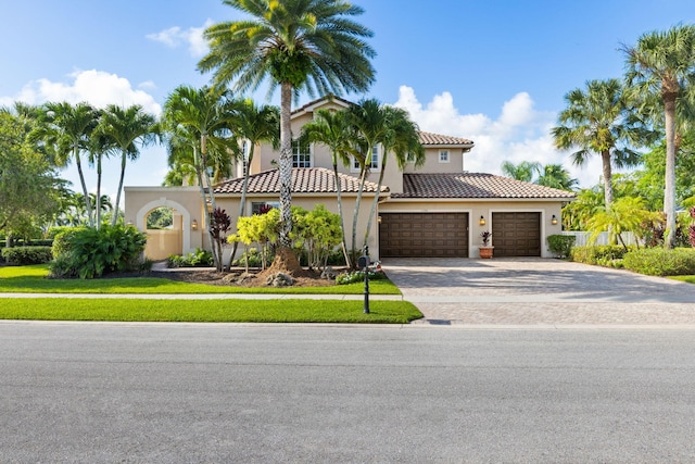 11788 Knightsbridge Pl, Wellington, FL 33449 - mediterranean / spanish-style home featuring stucco siding, an attached garage, driveway, and a tile roof