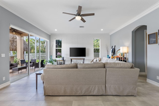 living room with ornamental molding, light tile patterned floors, and ceiling fan