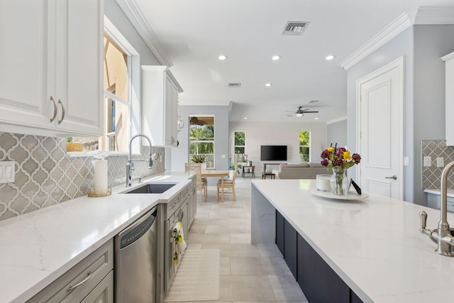 kitchen with ceiling fan, backsplash, sink, and stainless steel dishwasher