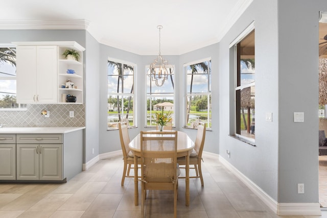 tiled dining area with crown molding and a notable chandelier