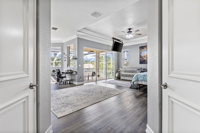 bedroom featuring ornamental molding, a textured ceiling, dark hardwood / wood-style floors, and access to exterior