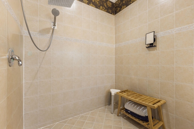 bathroom featuring tile patterned flooring, tiled shower, and tile walls