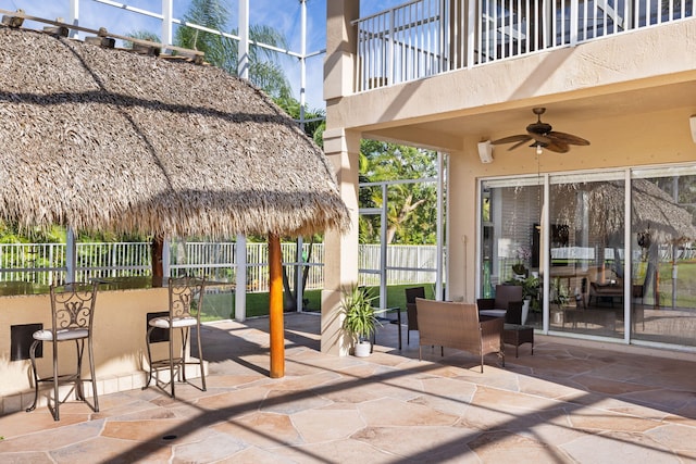 view of patio featuring ceiling fan and a balcony