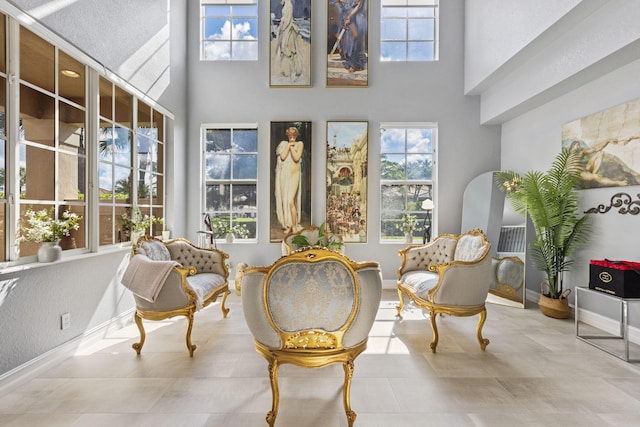 living area featuring light tile patterned floors and a high ceiling