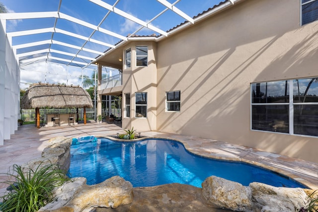 view of swimming pool featuring glass enclosure and a patio area