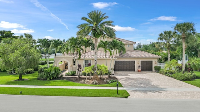 mediterranean / spanish-style home featuring a front yard and a garage