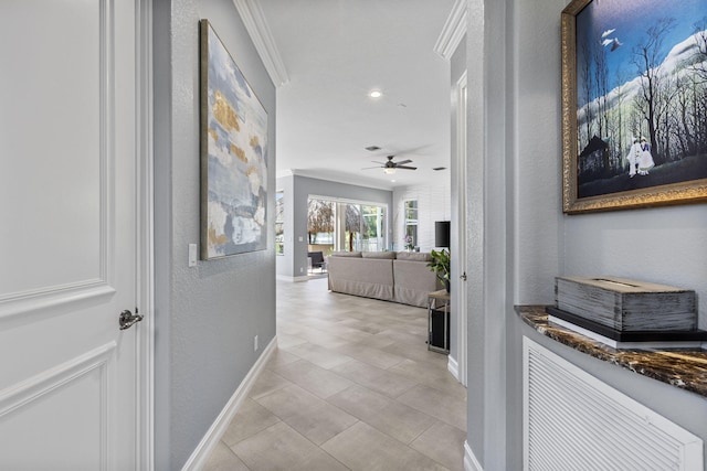 corridor featuring ornamental molding and light tile patterned floors