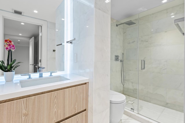 bathroom featuring vanity, toilet, a shower with shower door, and tile walls