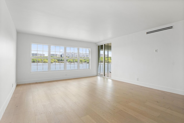 2185 Ibis Isle Rd Unit 10, Palm Beach, FL 33480 - empty room featuring light wood-style floors, visible vents, a water view, and baseboards