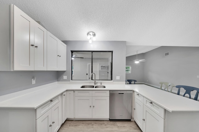 kitchen featuring kitchen peninsula, white cabinetry, sink, and stainless steel dishwasher