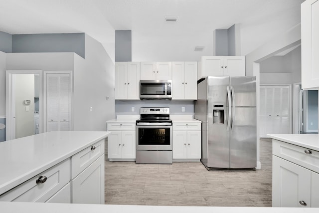 kitchen with white cabinets and appliances with stainless steel finishes