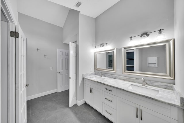 bathroom with tile patterned flooring, vanity, and lofted ceiling