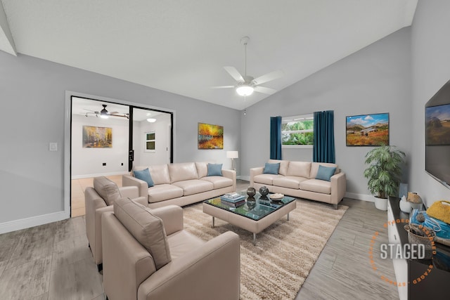 living room with ceiling fan, vaulted ceiling, and light hardwood / wood-style flooring