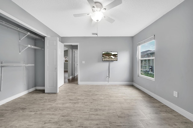 unfurnished bedroom with ceiling fan, a closet, and a textured ceiling