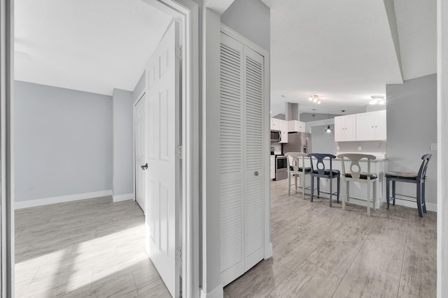 hallway with light hardwood / wood-style flooring