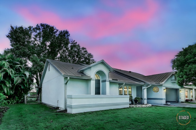 ranch-style home with a lawn and a garage