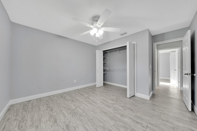 unfurnished bedroom with ceiling fan, a textured ceiling, and a closet