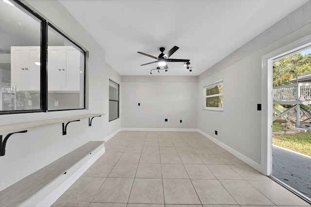 laundry area featuring ceiling fan and light tile patterned flooring