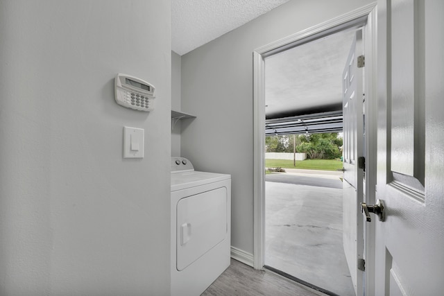 washroom featuring washer / dryer, a textured ceiling, and light hardwood / wood-style floors