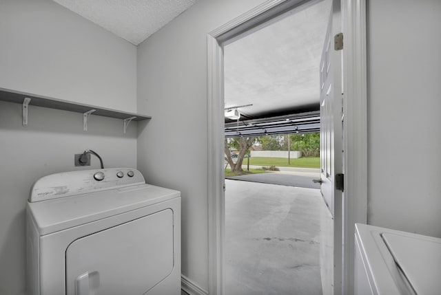 laundry area featuring washing machine and dryer and a textured ceiling