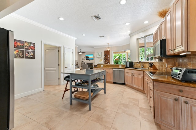 kitchen featuring tasteful backsplash, stainless steel appliances, sink, pendant lighting, and light tile patterned floors