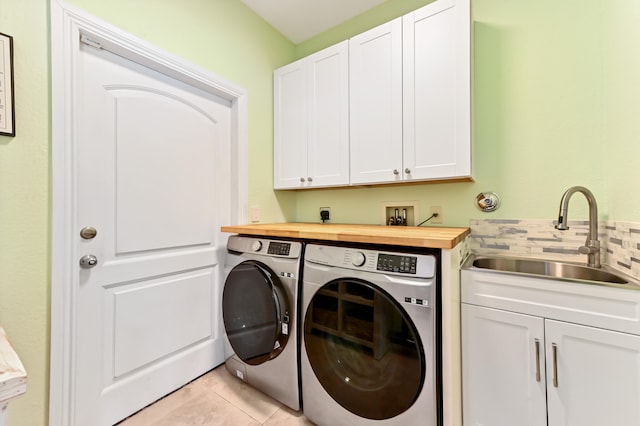 laundry room with cabinets, separate washer and dryer, sink, and light tile patterned floors