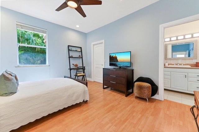 bedroom with ensuite bath, ceiling fan, light hardwood / wood-style flooring, and sink