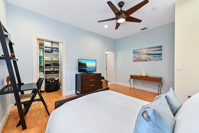 bedroom featuring a spacious closet, ceiling fan, light wood-type flooring, and a closet