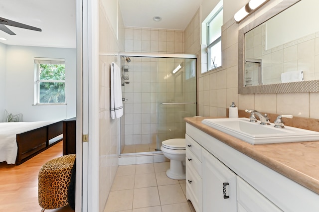 bathroom with vanity, tile patterned floors, tile walls, and a shower with shower door