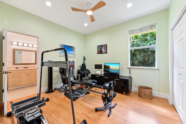 workout room featuring light hardwood / wood-style flooring and ceiling fan