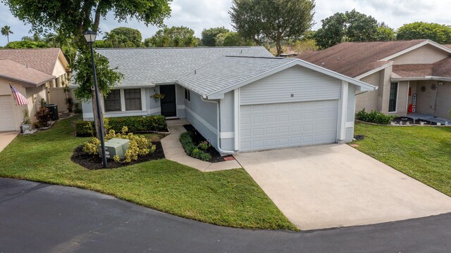 ranch-style house featuring a garage and a front yard