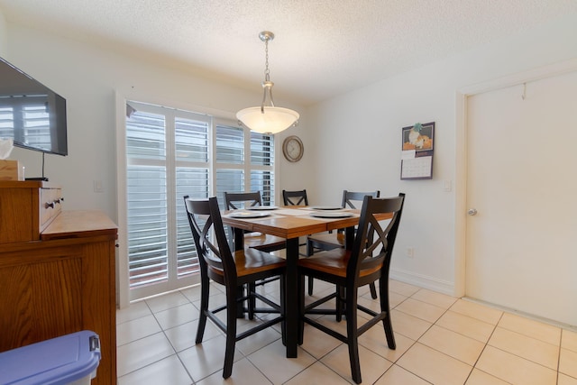 tiled dining area featuring a textured ceiling